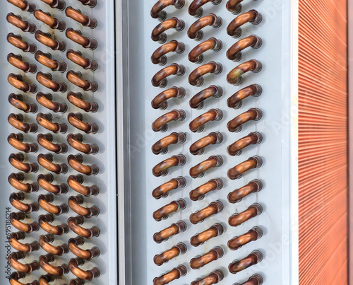 Close shot of copper plain tubes of a condenser coil.