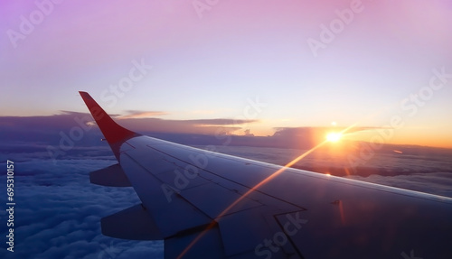 The sunset scene with Scenic View of the Wings of a aero plane flying above the clouds. Travelling by aero plane 