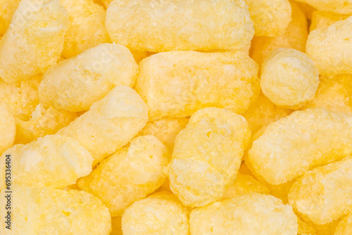 Heap of sweet corn puffs, top view close-up