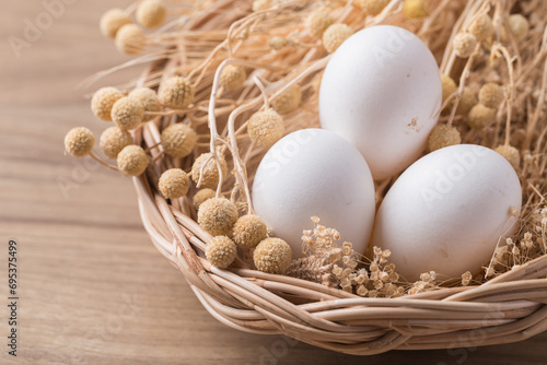 Organic white leghorn egg from free range farm in basket on wooden table