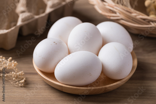 Organic white leghorn egg from free range farm in wooden bowl