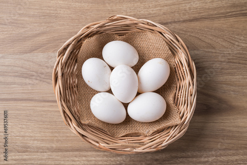 Organic white leghorn egg from free range farm in basket on wooden table, Top view