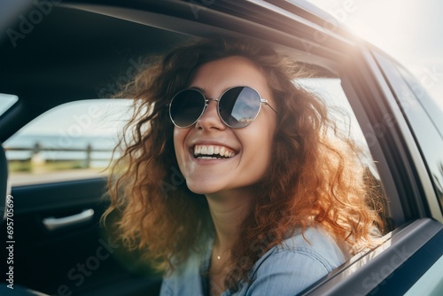Joven alegre con gafas de sol en coche, viviendo el momento en una ruta soleada