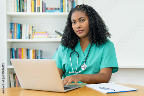 Pretty latin american medical student or female nurse working at computer