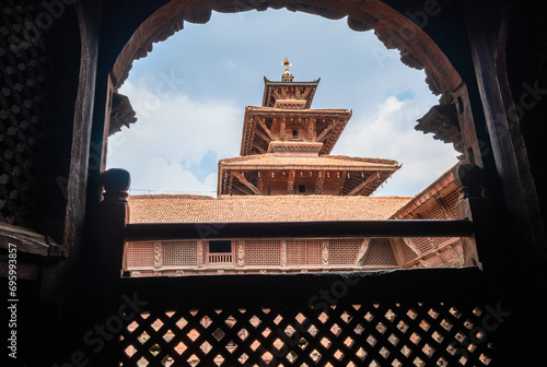 Real architecture masterpiece old temple view through the carved wood window, Patan Durbar Square royal medieval palace and UNESCO World Heritage Site. Lalitpur, Nepal.