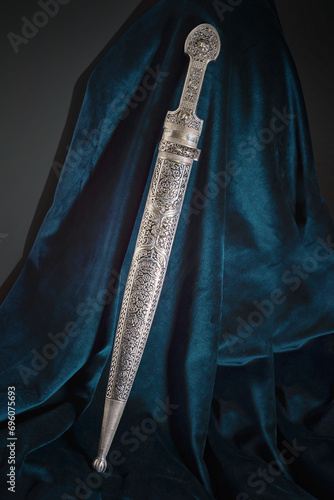 Circassian Adyghe Kama silver dagger on velvet dark material.