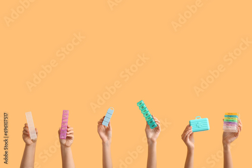 Female hands with different pill boxes on color background