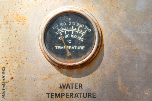 Water temperature gauge, using to measuring the temperature of the cooling water line of the machinery engine. Industrial equipment object photo.