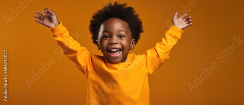 The joy of a little boy as he cheers with his arms upraised