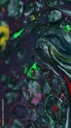 Ink mix background. Glitter dye. Fluid sequins art. Metallic black white green yellow color liquid oil bubbles in purple shimmering particles paint blend abstract hypnotic swirls.
