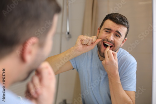 Man feeling discomfort while flossing 