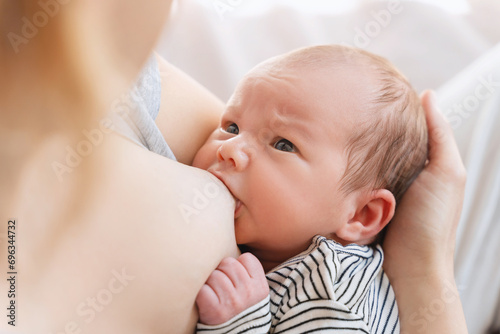 Mother breastfeeding baby. Baby eating mother's milk.