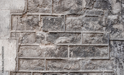 Close up old gray brick texture wall concept photo. Mediterranean architecture, urban city life