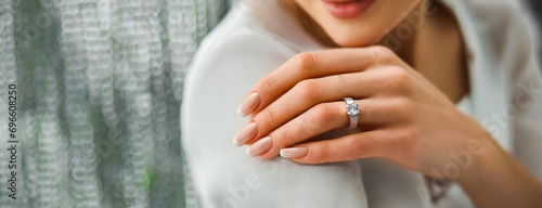 Woman Flaunting Her Elegant Diamond Engagement Ring. Close-up of a woman's hand as she shows off a sparkling diamond ring, symbolizing engagement