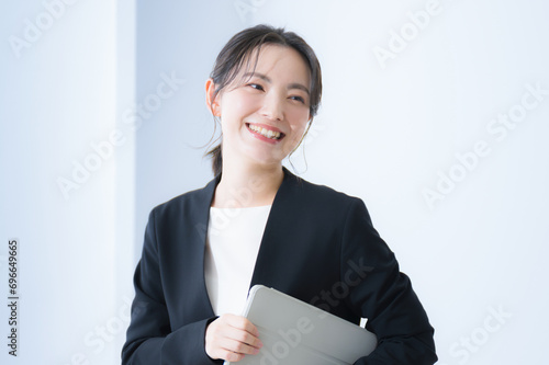 ノートパソコンを持ったビジネスウーマン 笑顔で振り返るクローズアップ 就職活動や働く女性のイメージ