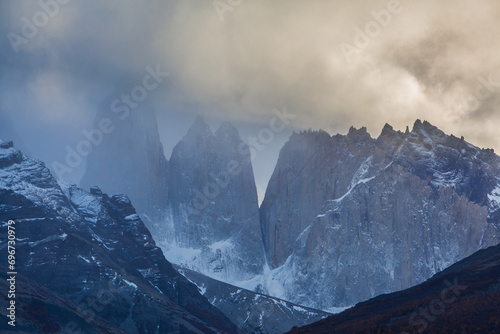 The jagged peaks of Torres del Paine disappearing in fog at sunset, Chile