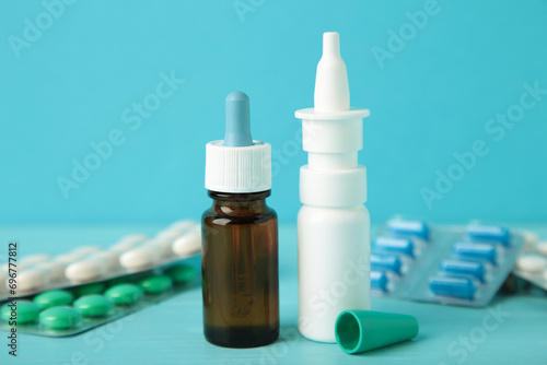 Nasal spray with pills on blue background. Top view