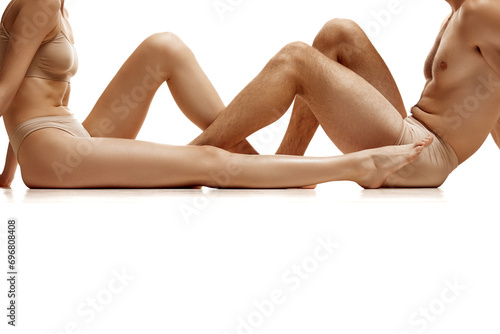 Cropped image of men's and women's bare legs against white studio background. Concept of natural beauty people, love, body care, hair removal, cosmetic products, fashion. Copy space for ad.