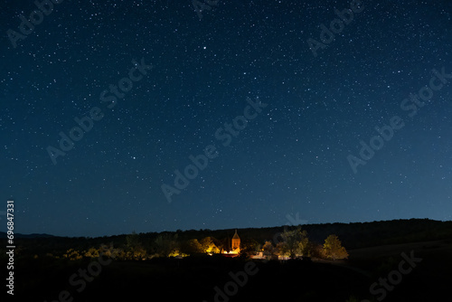 Lonely church illuminated under the starry sky.