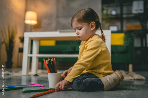 Toddler girl caucasian child play with crayons at home
