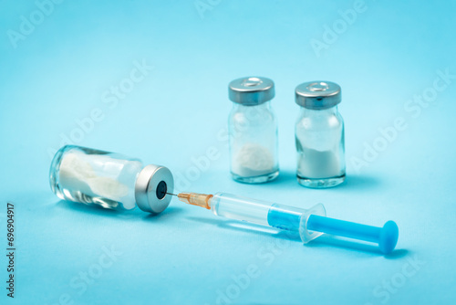 Syringe and needle with glass medical ampoule vials for injection. Medicine is dry white drug penicillin powder or liquid with of aqueous solution in ampulla