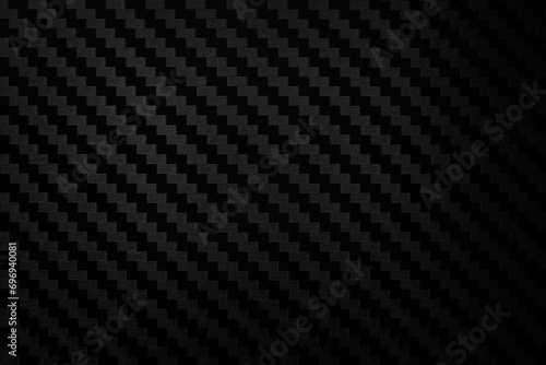 Carbon fiber composite raw material background. Carbon fiber texture. Dark Gray background with lighting.