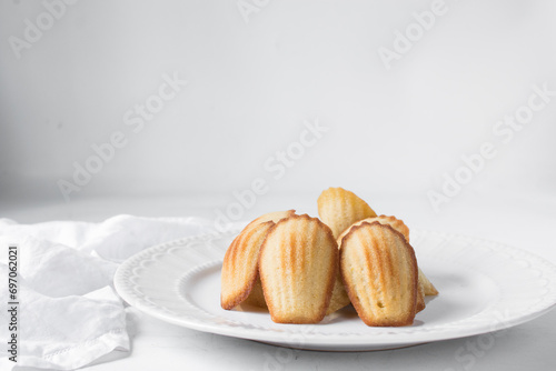 vanilla madeleines on a white plate, plain french vanilla madeleine cake or cookie