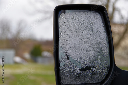 Atak zimy i śniegu, zaśnieżone lusterko samochodu.