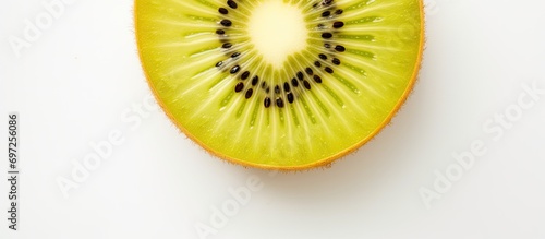 Top view of a sliced yellow kiwi fruit on a white table.