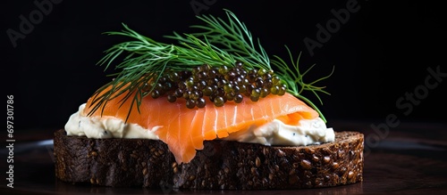 Smoked salmon, cream cheese, and caviar on pumpernickel bread with dill.