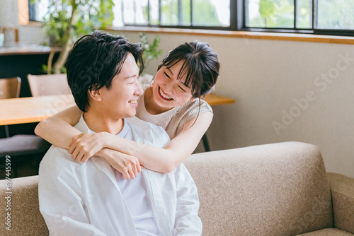 家のリビングにいる仲良しの若い日本人夫婦（スキンシップ） 