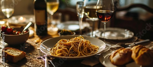 Truffled spaghetti with wine, breadsticks, and a table setup.