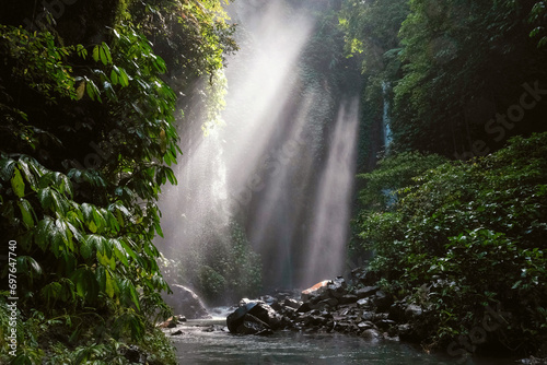 View of a creek leading to Hidden waterfall Sekumpul and sun beams. Bali, Indonesia.