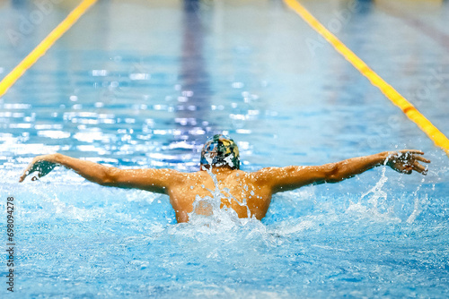 rear view male athlete swim butterfly at swimming competition, summer sports games