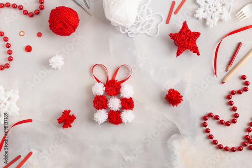 Making pom-poms from red and white threads. Ideas of Christmas decoration diy with kids. Gift made from pompoms