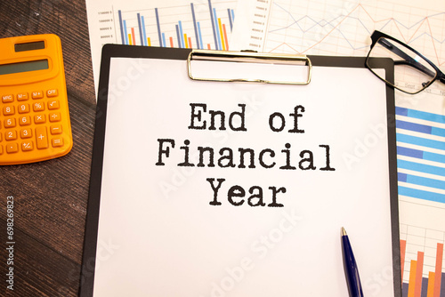 Finance and economics concept. The man is holding a pen and a notebook with the inscription - END OF FINANCIAL YEAR.
