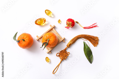 Composition with tangerines, lucky talisman and Chinese symbols on white background. New Year celebration