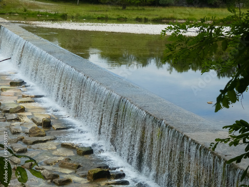 small waterfall with water of the wide river without people in the valley