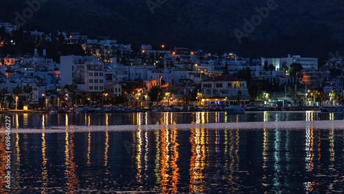 Night view of Bodrum city. Famous tourist city in evening lights, calm water of Bodrum bay. Turkey (Turkiye)