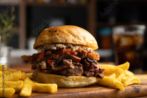 Brisket sandwich with sweet pepper, caramelized onion and aioli sauce served with a portion of French fries