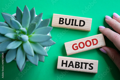 Build good habits symbol. Wooden blocks with words Build good habits. Beautiful green background with succulent plant. Businessman hand. Business and Build good habits concept. Copy space.