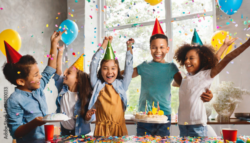 Happy multicultural group of kids having fun during birthday party with confetti