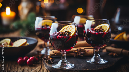 Christmas mulled red wine with spices and fruits on a wooden rustic table. Traditional hot drink at Christmas time
