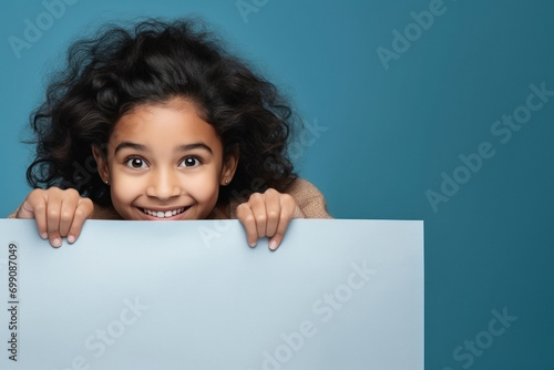 little indian girl behind a blank poster