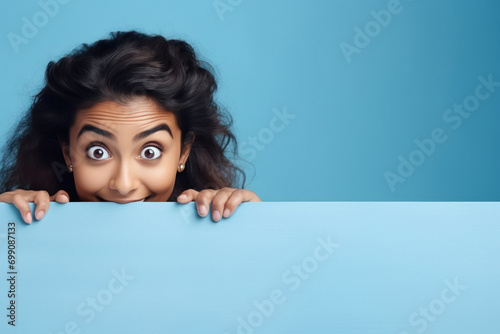 young indian woman behind a blank poster