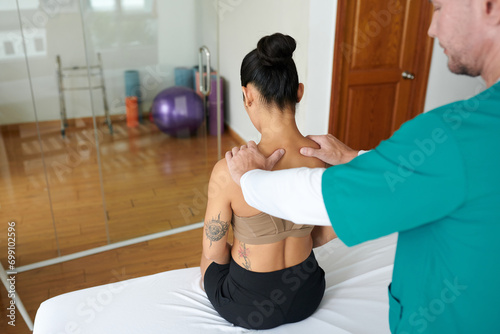 Massage therapist helping patient to get rid of muscle tension in neck and shoulder area