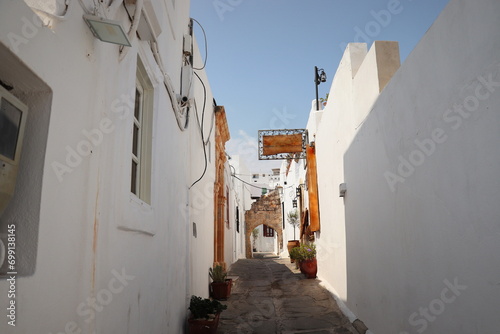 Narrow street in Lindos town on Rhodes island, Dodecanese, Greece. Beautiful scenic old ancient white houses . Famous tourist destination in South Europe