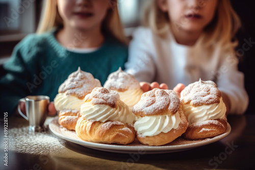 Children hold a plate of whipped cream-topped Swedish semla buns