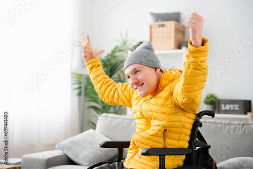 Happy young man with cerebral palsy smiling at home