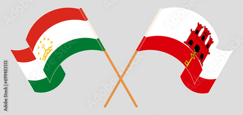 Crossed and waving flags of Tajikistan and Gibraltar